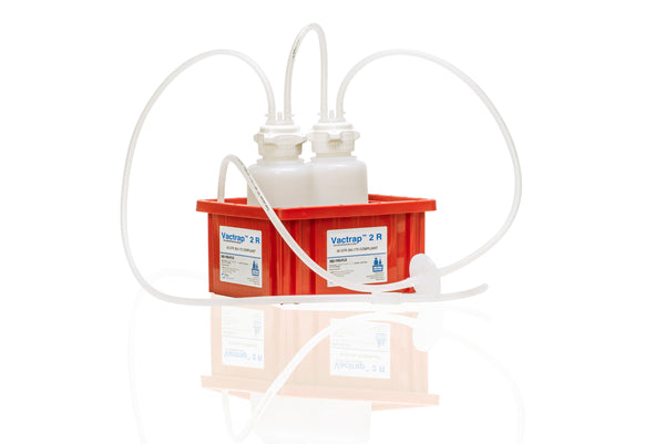 A red plastic carrier box containing two white plastic bottles connected by clear tubing, photographed on a clean white background with a faint reflection below.